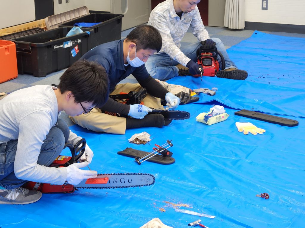 研修会にてチェーンソーのメンテナンスをする参加者の様子